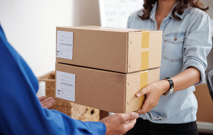 photo of a woman receiving two packages from a delivery-person