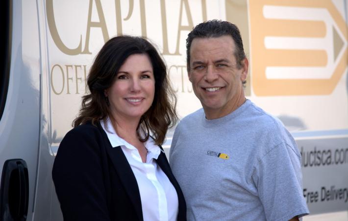 carolyn and richard standing in front of a white van with the capital office products logo printed on it